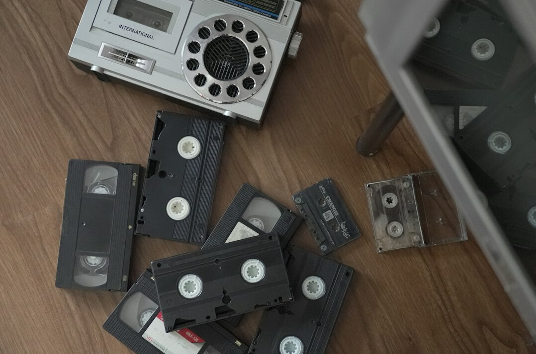 Editing desk with vintage videotape reels beside a modern video monitor